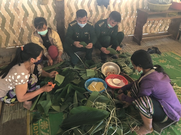 Cán bộ, chiến sĩ Đồn Biên phòng Đăk Nhoong cùng người dân gói bánh chưng đón Tết.